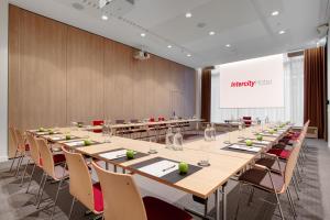 IntercityHotel Wiesbaden في فيسبادن: قاعة المؤتمرات مع طاولة وكراسي طويلة