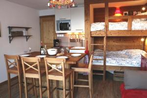 a room with a table and a bunk bed at Appartements Immeuble Zodiaque in Le Corbier