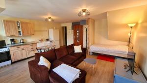 ein Wohnzimmer mit Sofa und eine Küche in der Unterkunft Le Studio Bis - Appartement meublé tout confort Centre Ville in Pont-Sainte-Maxence