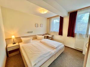 a bedroom with a white bed and a window at Gästehaus Südheide in Hambühren