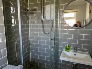 a woman taking a picture of a bathroom with a mirror at Gone To The Beach Flat 1 in Hunstanton