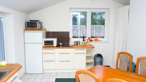 a kitchen with white cabinets and a table with a microwave at ITM Hotel Bettkästchen am Sachsenwald in Reinbek