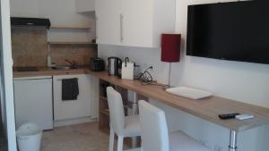 a kitchen with a desk with a television on it at Kira in Uzès