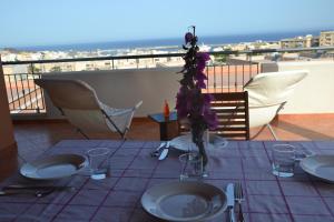 a table with a purple table cloth on a balcony at Appartamento Yucca in Pantelleria