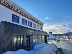 a store with snow in front of a building at Auberge & Campagne in Saint-Férréol-les-Neiges
