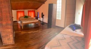 a room with a bed and a living room with wood floors at Carnaval Inn Salvador in Salvador