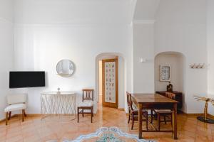 un salon avec une table, des chaises et une télévision dans l'établissement Romantic Apartament 2 Piazza del Popolo, à Rome