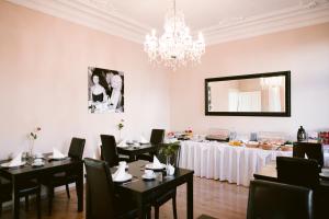 a dining room with tables and chairs and a chandelier at Boutique Hotel Villa Oberkassel in Düsseldorf