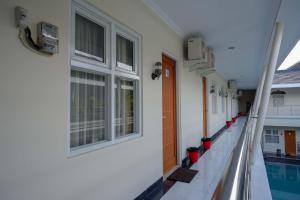 a corridor of a building with a swimming pool at Urbanview Hotel Syariah Casa Azmya Yogyakarta in Kejayan