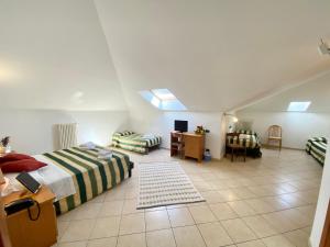 Cette grande chambre comprend deux lits, un bureau et une table. dans l'établissement Albergo Villa Ada, à Borgio Verezzi