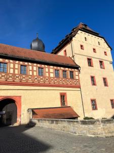 un grand bâtiment en briques avec un toit brun dans l'établissement Ferienwohnung Bergkristall, à Forchheim