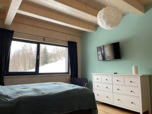 sypialnia z łóżkiem, oknem i komodą w obiekcie Chalet Rokytnice w Rokitnicach nad Izerą +10 zdjęć