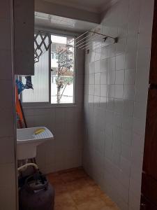 a small bathroom with a sink and a window at Apto Aconchegante Praia Grande in Praia Grande
