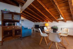 een woonkamer met een tafel en een blauwe bank bij Apartamentos Top Medieval in Sigüenza
