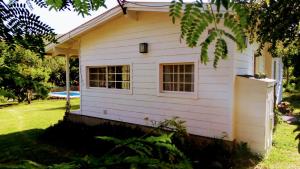 a white house with a window in a yard at Chalet Las Doritas in La Cumbre