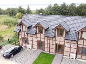 widok z powietrza na dom z samochodem zaparkowanym przed budynkiem w obiekcie Residence in Zastan with Lake Access w mieście Zastań