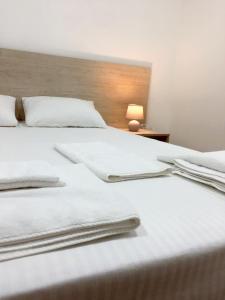 a bed with white sheets and towels on it at Мини-Отель Белый Квадрат in Kyiv