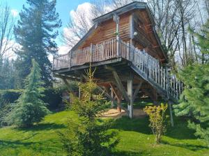 a cabin in the woods with a large deck at La Cabane à l'Orée des Bornes in Évires