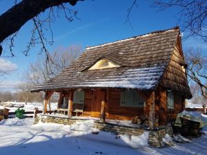 a log cabin with snow on the roof at Jabłoniowy Sad Kalwaria Pacławska in Kalwaria Pacławska