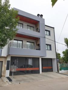 un gran edificio blanco con dos puertas de garaje en RIALTO dpto COCHERA Cubierta Asador individual, en Villa Mercedes 8 fotos más