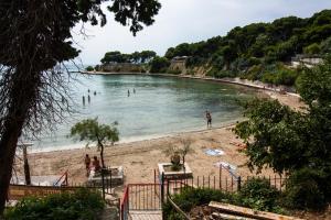 a beach with a bunch of people in the water at Apartments Beautiful Sandy Beach in Split