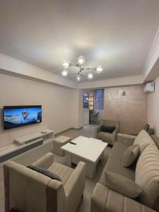 uma sala de estar com um sofá e uma televisão em Deluxe apartment in the city center em Yerevan