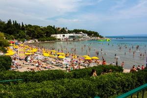 a crowd of people on a beach with umbrellas at Apartments Beautiful Sandy Beach in Split