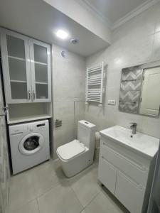 uma casa de banho branca com uma máquina de lavar roupa e um lavatório em Deluxe apartment in the city center em Yerevan