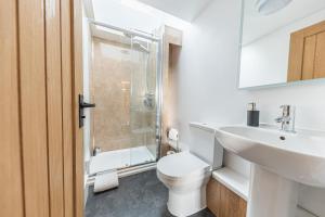 uma casa de banho com um WC, um lavatório e um chuveiro em The Black Dog Cottage em Dalton in Furness