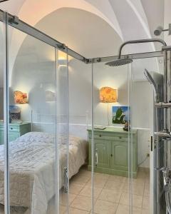 um quarto com uma cama e uma cabina de duche em vidro em La Volta em Manduria