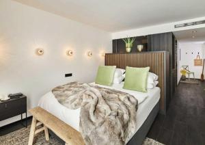 a bedroom with a large bed with green pillows at Designhotel ÜberFluss in Bremen