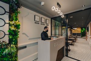 a man sitting at a counter in a restaurant at Eleven Hotel Baku in Baku
