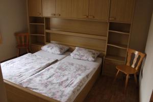 um quarto com uma cama, uma cadeira e prateleiras em Gästehaus Alpensicht em Grafenhausen