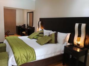 1 dormitorio con 1 cama grande con manta verde en Cedar Rest Boutique Hotel, en Chartwell