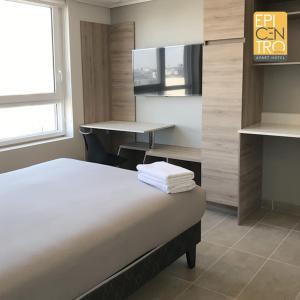 Кровать или кровати в номере Epicentro Suites Apart Hotel - Temuco