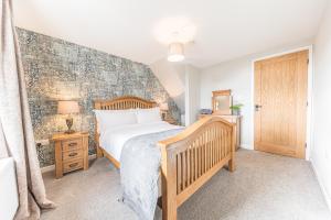 um quarto com uma cama e uma cabeceira em madeira em The Black Dog Cottage em Dalton in Furness
