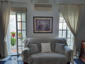 a couch sitting in a living room with windows at Apartamento en casco histórico in Estepona