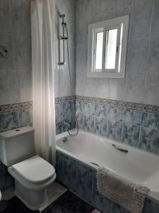 a bathroom with a toilet and a tub and a sink at Apartamento en casco histórico in Estepona