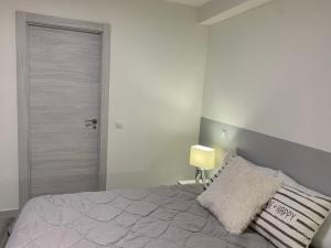 a white bedroom with a bed and a door at Mirrooms in Oviedo