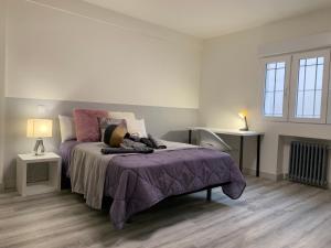 1 dormitorio con 1 cama con manta morada en Mirrooms, en Oviedo