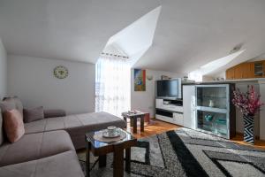 ein Wohnzimmer mit einem Sofa und einem TV in der Unterkunft Taira in Dubrovnik