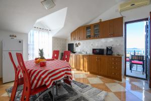 eine Küche mit einem Tisch mit einem roten und weißen Tischtuch in der Unterkunft Taira in Dubrovnik