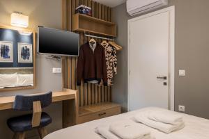 a room with a bed and a desk and a tv at MIRMA CITY Old Town in Chania