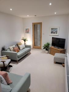 a living room with a couch and a flat screen tv at Explore East Devon from here.. in Exmouth