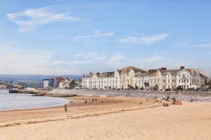 un grupo de personas en una playa con edificios en Explore East Devon from here.. en Exmouth
