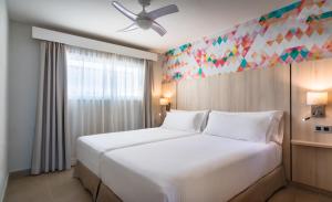 1 dormitorio con 1 cama blanca grande y ventilador de techo en Allegro Isora en Puerto de Santiago
