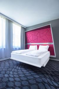 1 dormitorio con 1 cama grande y cabecero rosa en Magic Hotel Xhibition, en Bergen