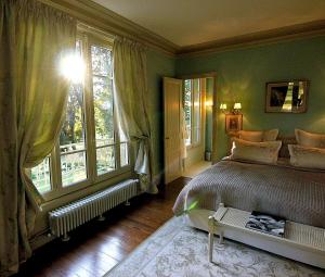 a bedroom with a bed and a large window at Château de la Chaix in Saint-Christophe-en-Brionnais