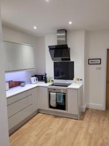 a kitchen with white cabinets and a stove top oven at Explore East Devon from here.. in Exmouth