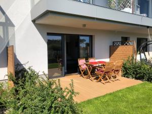 a wooden deck with a table and chairs on it at Apartament Julian Seaside Gardenia in Dziwnów